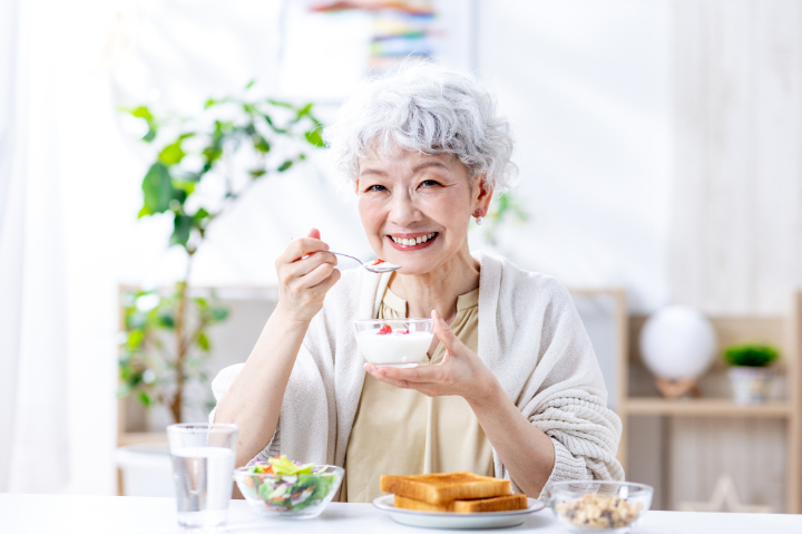 自分に合った入れ歯を装着し美味しく食事をいただく女性