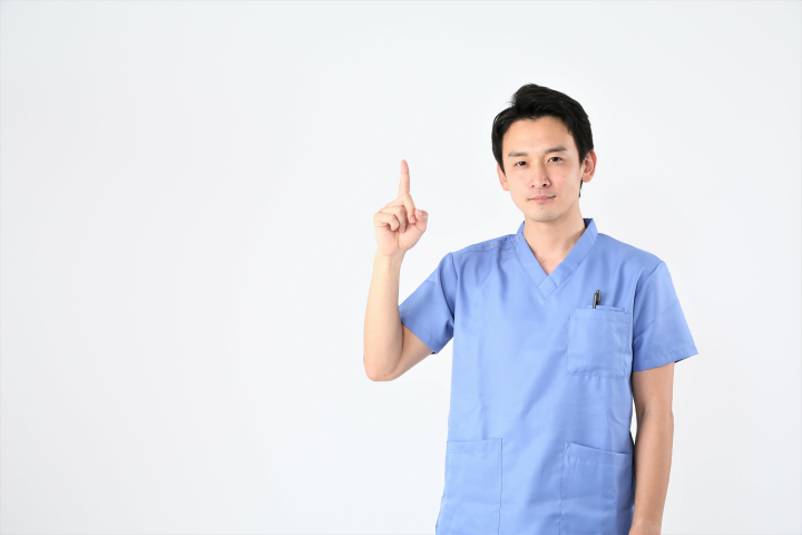 根管治療を中断すると起こることについて説明する歯科医師の男性