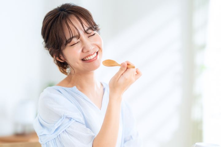 横向きに生えた親知らずを抜歯して食事を楽しむ女性