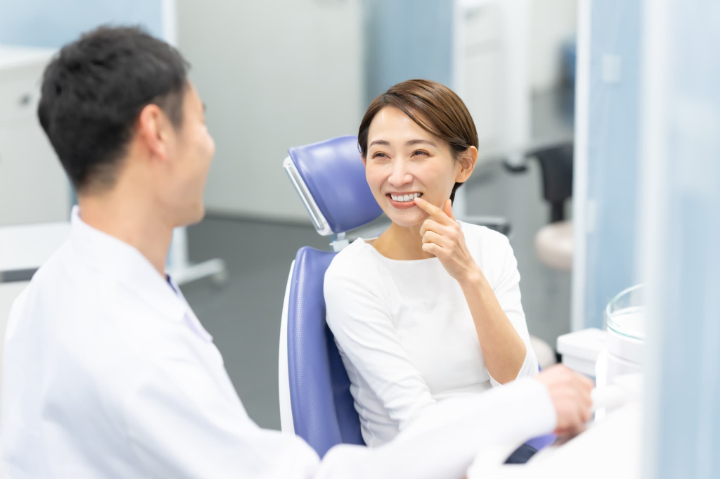 後戻りについて歯科医師に相談する女性