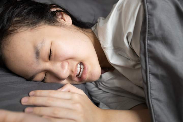 睡眠中に歯ぎしりをする女性