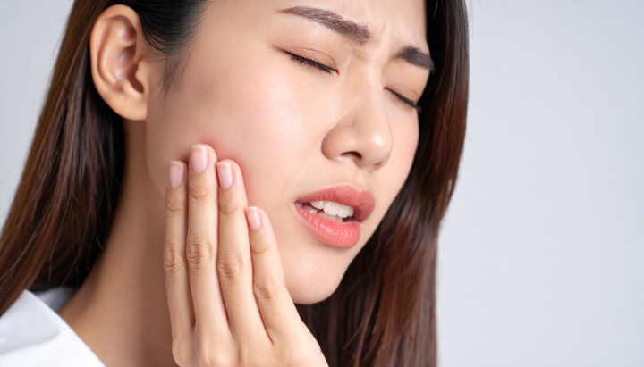 根管治療をしたが、まだ歯の痛みを感じている女性