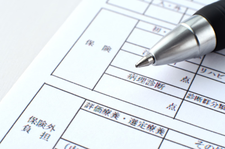 診療報酬明細書を示して保険と自費のクリーニングの違いを説明するイメージ