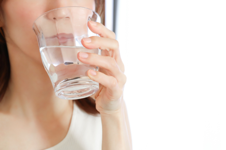 インビザライン装着中に水を飲む女性