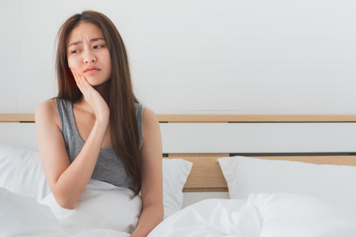 矯正治療で歯が痛いと感じている女性