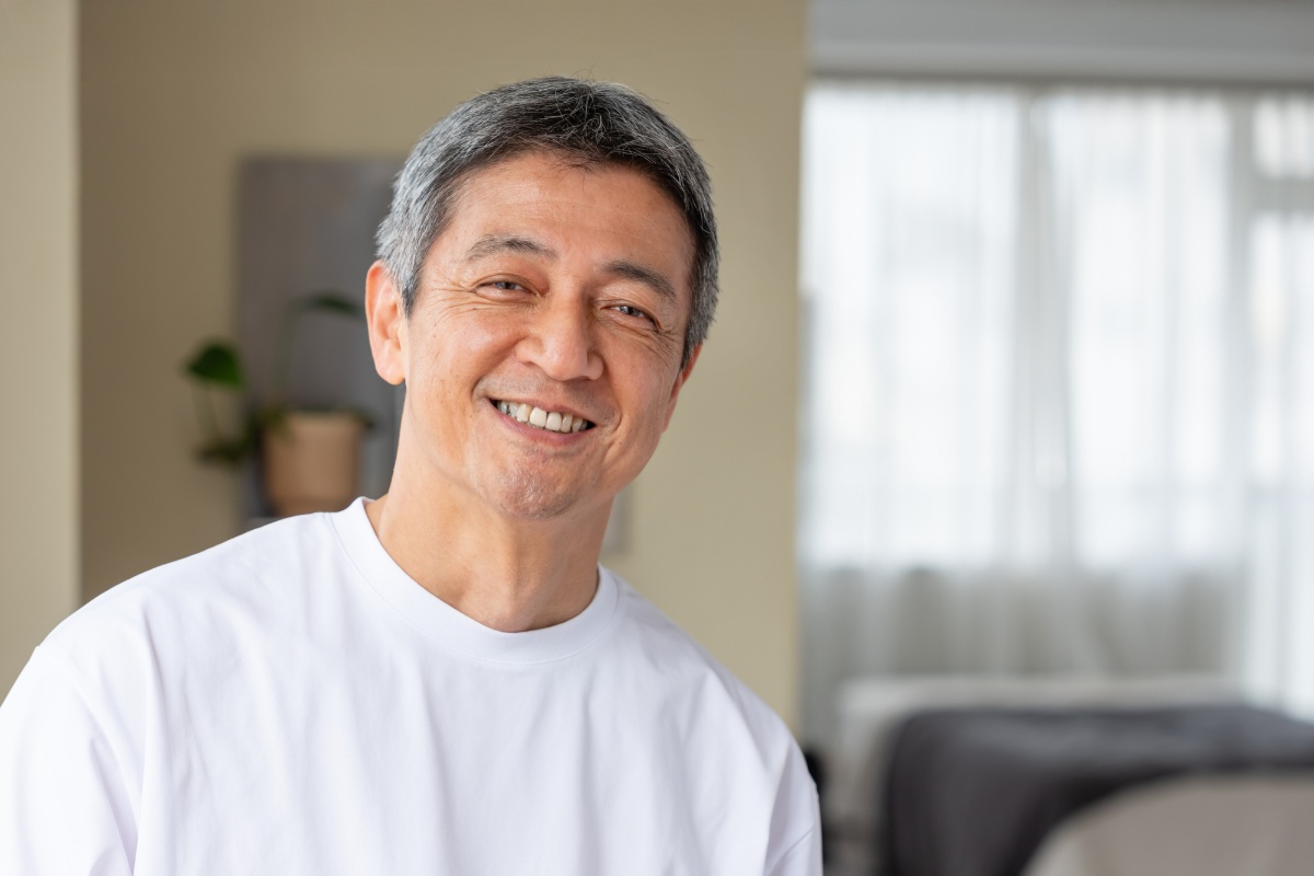 適切なケアで歯周病を予防できた男性が満足そうに笑っているイメージ