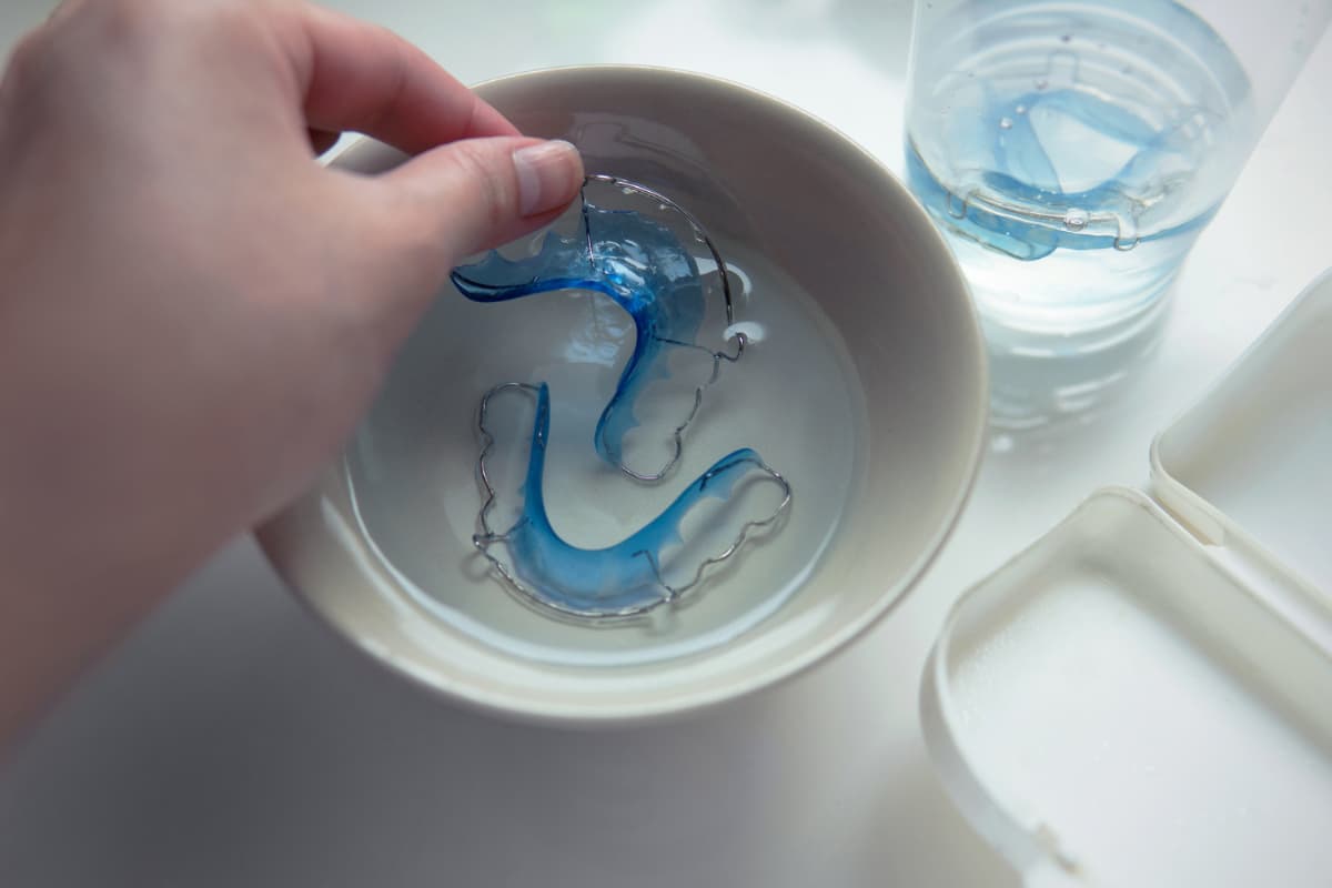 リテーナーを専用の洗浄剤を使ってお手入れする様子